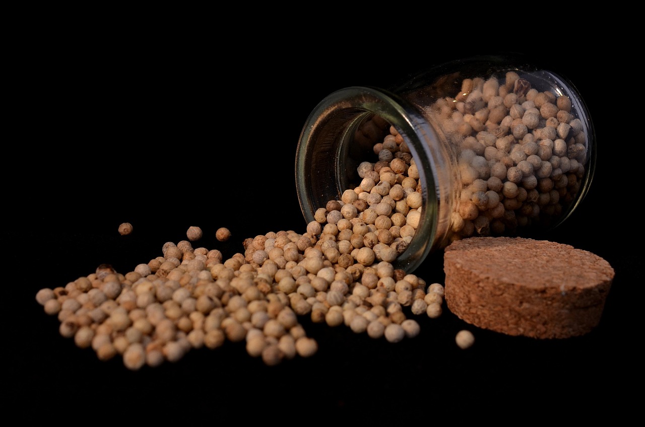 A glass jar filled with used natural wine corks on a wooden kitchen counter